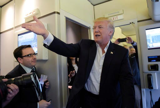 President Donald Trump talks to reporters on board Air Force One as he arrived to speak at his "Make America Great Again Rally" at Orlando-Melbourne International Airport in Melbourne, Fla., Saturday, Feb. 18, 2017.