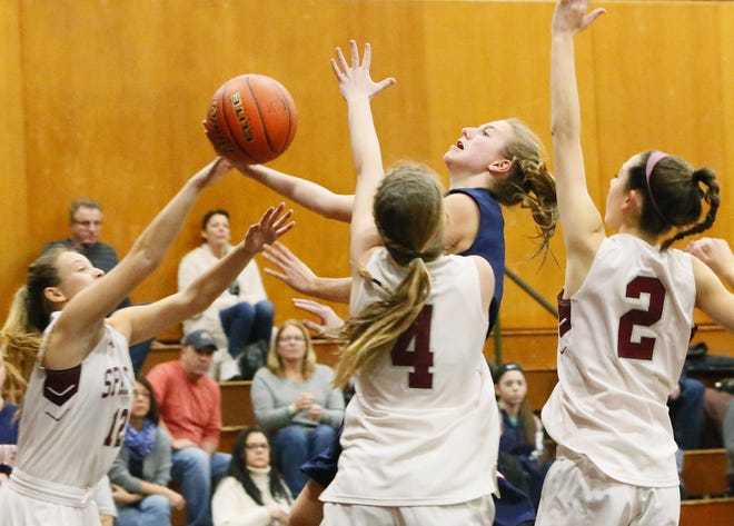 Apponequet's Sarah Milligan takes the ball to the basket against Bishop Stang defenders, left to right, Mollie Duclos, Lilly Syron, and Catherine Yeargin. MIKE VALERI/THE STANDARD-TIMES/SCMG