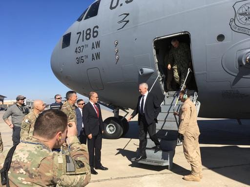 U.S. Secretary of Defense Jim Mattis, second from left, is greeted by U.S. Ambassador Douglas Silliman as he arrives at Baghdad International Airport, Iraq, on an unannounced trip Monday. Mattis said Monday the United States does not intend to seize Iraqi oil, shifting away from an idea proposed by President Donald Trump that has rattled Iraq's leaders.