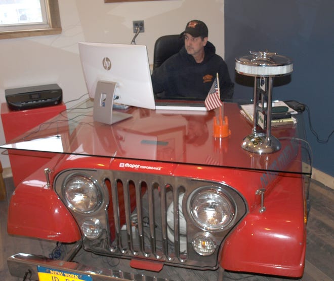 Mike Iacovelli, owner of Orange County Jeepworks, sits behind his "Jeep" desk at the shop's new location, 328 Petticoat Lane in Bloomingburg. [DONNA KESSLER/Times Herald-Record]