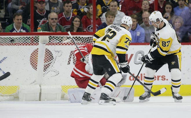 Pittsburgh Penguins' Sidney Crosby (87) shoots past Carolina Hurricanes goalie Cam Ward and scores as Penguins' Patric Hornqvist (72), of Sweden, watches during the second period of the Penguins' win Tuesday in Raleigh, N.C.