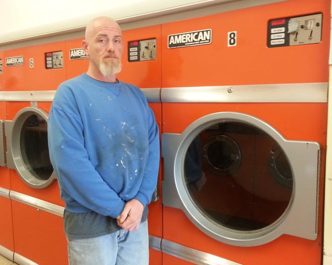 Darrin Landers stands in front of dryers at Lake Lady Laundry that were allegedly damaged by two people charged with burglary. [MIKE MURPHY/MESSENGER POST MEDIA]