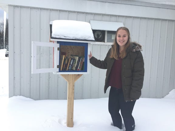 Pickford High School student Edyn Nettleton smiles at the Little Free Library at Midpoint Marathon in Kinross Township. Nettleton has taken on a project that involves designing, building, and setting up the book lending “houses” in the Pickford community and surrounding areas.