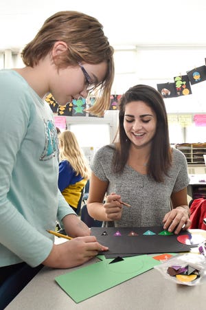 Fourth grade Village School student Allie Campbell, 9, works together with high school student Carolyn Arthur creating fraction animals during a mentoring program with high school student athletes at the Village School. [Wicked Local Staff Photo / David Sokol]