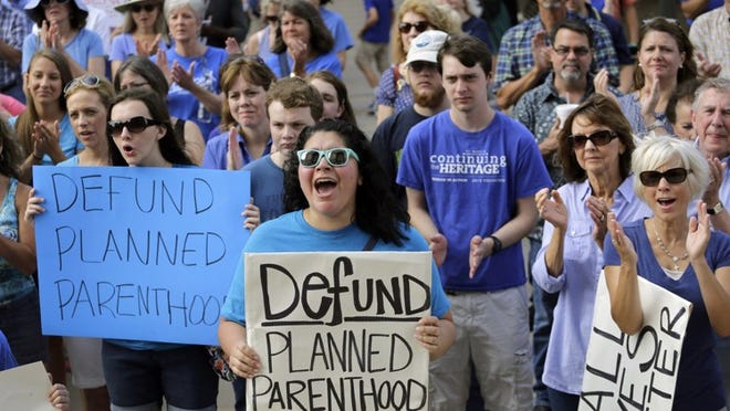 In a photo from July 28, 2015, Erica Canaut, center, cheers as she and other abortion opponents rally on the steps of the Texas Capitol to condemn the actions of Planned Parenthood as depicted in undercover videos. ERIC GAY/ASSOCIATED PRESS