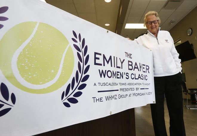 Emily Baker, the namesake of the newly-estalished Emily Baker Women's Classic, stands in front of a banner advertising the fundraiser for local youth tennis, inside the Emily Baker Indoor Tennis Center at Center Court Tuscaloosa. Baker has been on of the sport's greatest local ambassador, and the Tuscaloosa Tennis Association is honoring her with a tournament named in her honor. [Staff Photo/Gary Cosby Jr.]