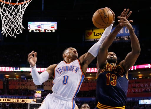 Oklahoma City Thunder guard Russell Westbrook (0) grabs a rebound in front of Cleveland Cavaliers center Tristan Thompson (13) during the first quarter of an NBA basketball game in Oklahoma City on Feb. 9, 2017. (AP Photo/Sue Ogrocki, File)
