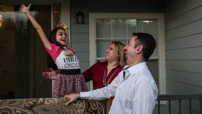 Saif Al Zuwaydee, Rusul Khudhair and Noor Al Zuwaydee, 10, share a light-hearted moment at their home in Northwest Austin.