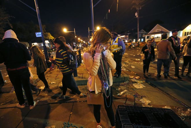 A woman talks on a phone at the scene of where a truck slammed into a crowd and other vehicles, causing multiple injuries, Saturday during the Krewe of Endymion parade in in the Mid-City section of New Orleans. Police Chief Michael Harrison says one person in custody and that he is being investigated for driving while intoxicated. [Gerald Herbert/The Associated Press]