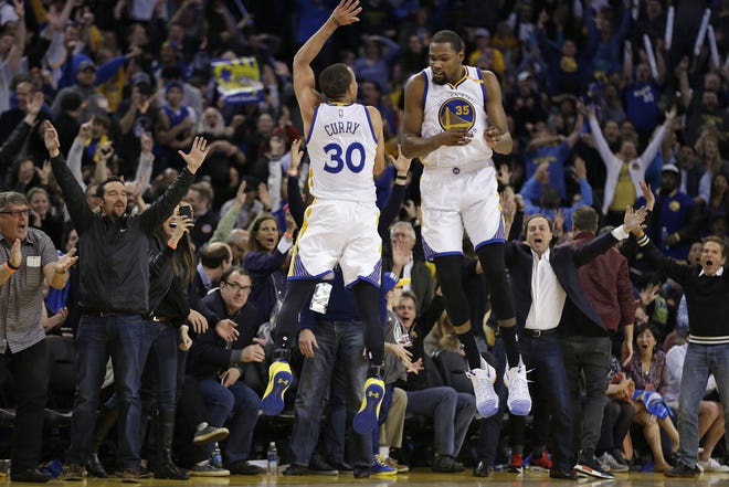 Golden State Warriors' Stephen Curry (30) and Kevin Durant (35) celebrate a score against the Los Angeles Clippers during the second half of an NBA basketball game Thursday in Oakland, Calif. [AP Photo / Ben Margot]
