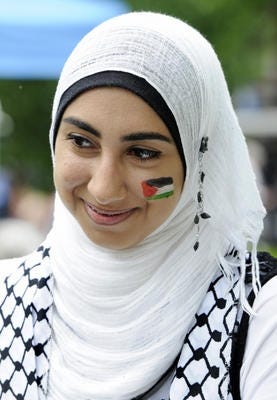 Tina Russell / Observer-Dispatch Haneen Alsaad talks about her native country of Palestine with the flag painted on her cheek during a World Refugee Day event at Mohawk Valley Community College Saturday, June 20, 2015. Attendees enjoyed different styles of music, an international fashion show, arts and crafts and more.