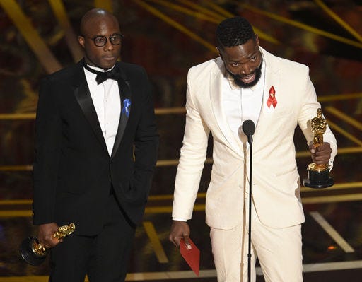 Barry Jenkins, left, and Tarell Alvin McCraney accept the award for best adapted screenplay for "Moonlight" at the Oscars on Sunday, Feb. 26, 2017, at the Dolby Theatre in Los Angeles. (Photo by Chris Pizzello/Invision/AP)