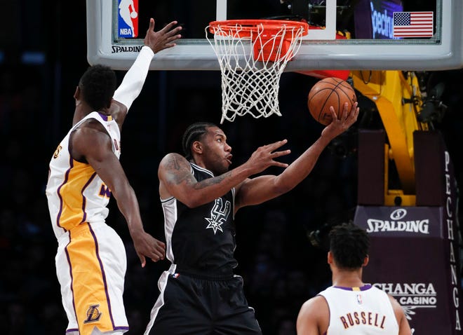San Antonio Spurs’ Kawhi Leonard, center, puts up a shot past Los Angeles Lakers’ Julius Randle on Sunday in Los Angeles. (AP Photo/Jae C. Hong)