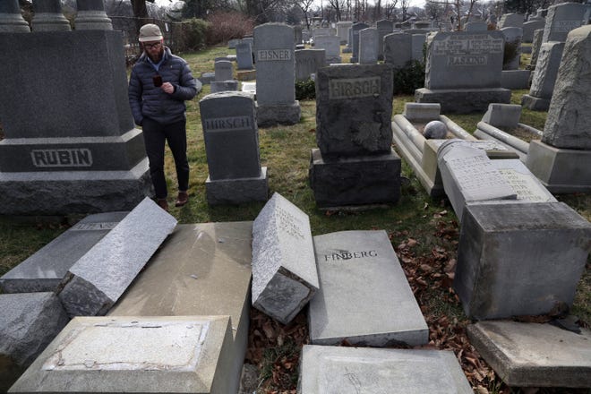 Rabbi Joshua Bolton of the University of Pennsylvania's Hillel center surveys damaged headstones at Mount Carmel cemetery Monday, Feb. 27, 2017, in Philadelphia. More than 100 headstones have been vandalized at the Jewish cemetery in Philadelphia, damage discovered less than a week after similar vandalism in Missouri, authorities said. THE ASSOCIATED PRESS