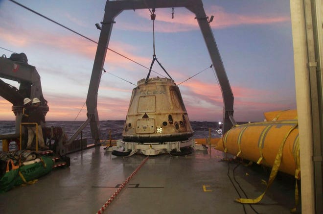 SpaceX's Dragon capsule sits aboard a ship in the Pacific Ocean after returning from the International Space Station in 2015, carrying about 3,700 pounds of cargo for NASA. SpaceX announced Monday that it would send two paying customers to the moon next year on a private flight aboard the Dragon capsule.
