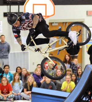 Ell-Saline Elementary School students watch a cyclist with Lonestar Action Sports as he lands on a ramp after a jump Monday in the school’s gym.