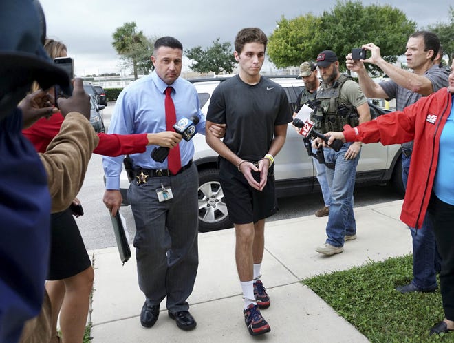 FILE - In this Monday, Oct. 3, 2016, file photo, Austin Harrouff is transported by detectives to the Martin County Jail from St. Mary's Hospital in Florida. Harrouff, the Florida college student accused of randomly killing a couple and chewing on the dead man's face, told TV personality Phil McGraw he had been running from a demon-like figure named Daniel before the attack. In a video released Tuesday, Feb. 28, 2017, by prosecutors, Harrouff told McGraw he only had vague memories of killing John Stevens and Michelle Mishcon last Aug. 15. (Richard Graulich/Palm Beach Post via AP)