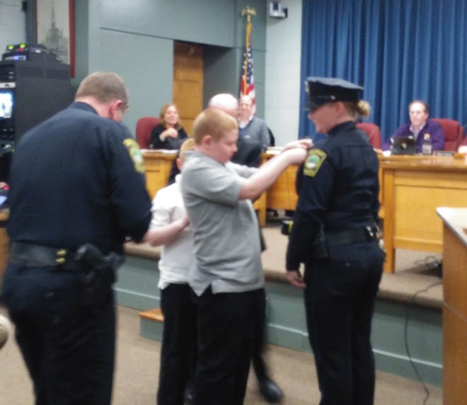 Newly-promoted Walpole Police Sgt. Jackie Hazeldine is formally recognized in her new role at Tuesday's selectmen's meeting. Her sons, Jack and James, pinned her badge. Photo by Alison Bosma
