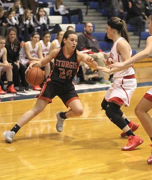 The Lady Trojans’ Harmony Groves dribble the ball past a Coldwater defender.