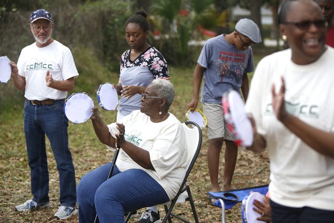 Vivian Filer of the Cotton Club Museum and Cultural Center plays a tambourine Saturday with a group of people at the Cotton Club during the "Cotton to the Cade: A Walking Tour." [Brad McClenny/Special to the Guardian]