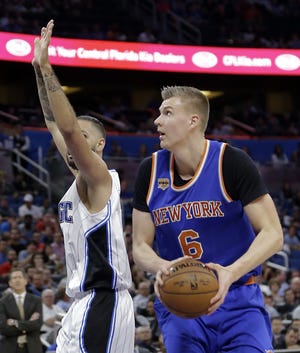 Knicks' Kristaps Porzingis (6) looks for a shot as he gets around the Magic's Evan Fournier during the first half of Wednesday night's game in Orlando, Fla. Porzingis, who missed two games with a sprained ankle, scored 20 points to power the Knicks past the smaller Magic. [The Associated Press]