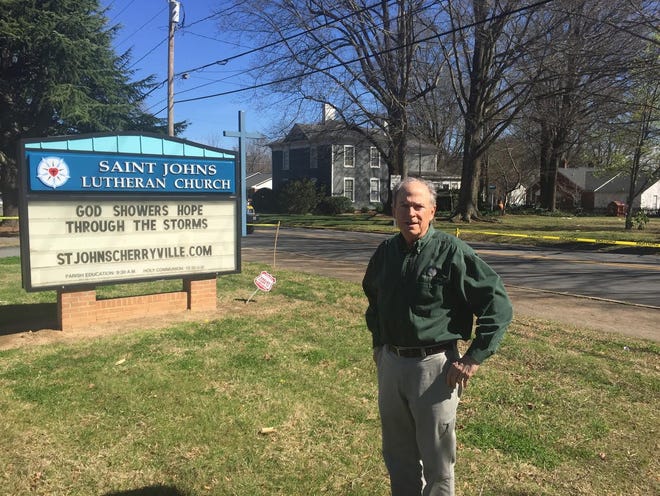 John Propst stands near a marquee he changed to note the storm that hit his church Wednesday.

[ADAM LAWSON/The Gazette]