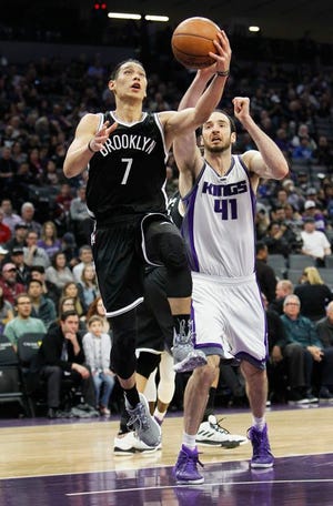 Brooklyn Nets guard Jeremy Lin drives to the basket past Kings defender Kosta Koufos during the first half of Wednesday night's game in Sacramento, Calif.