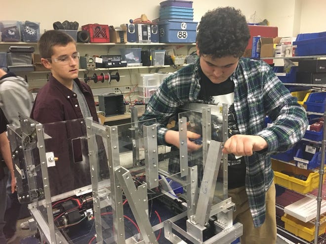 Members of Bridgewater-Raynham Regional High School's robotics team work on their robot in February.