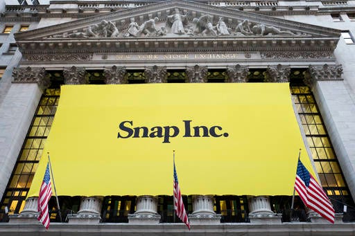 A banner for Snap Inc. hangs from the front of the New York Stock Exchange, Thursday, March 2, 2017, in New York. The company behind the popular messaging app Snapchat is expected to start trading Thursday after a better-than-expected stock offering. (AP Photo/Mark Lennihan)