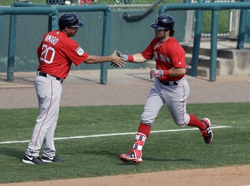 Red Sox outfielder Andrew Benintendi, right, shakes hands with third base coach Ruben Amaro Jr. after hitting a home run in Boston's 9-1 spring training win over the Atlanta Braves.