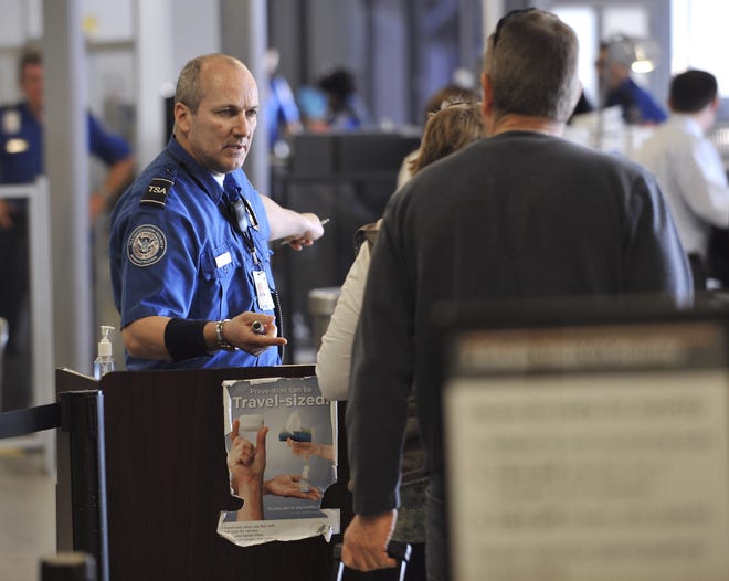 A TSA employee checks documents for passengers in line at a security checkpoint at Logan International Airport in Boston in 2010. Pat-downs will become more intrusive, TSA officials said. [JOSH REYNOLDS/ASSOCIATED PRESS FILE]
