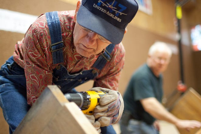 Members of the Northside Rotary Club prepare a bench for sanding and painting at Girls Inc. of Bay County in 2012. Rotary is one of several civic clubs that meets regularly in Bay County. [NEWS HERALD FILE PHOTO]