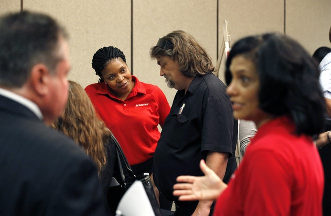 Job seekers attend a career fair. Americans increasingly are switching jobs to procure pay raises they might not get by staying in one place. [AP FILE]