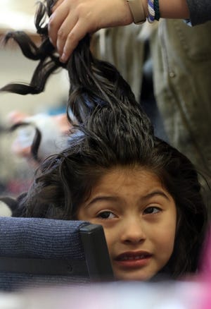 Runway model Marelyn has her hair done by Makenzie Zammarelli prior to the start of the second-annual The Art of Fashion show at Webb Street School Saturday evening, March 4, 2017, to raise money for a playground. [MIKE HENSDILL/THE GAZETTE]