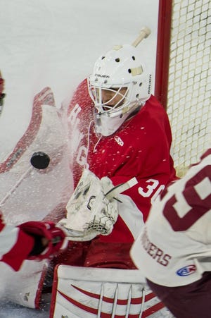 Hingham goaltender Robbie Kornack concentrates on the puck while snow flies at him during Hingham's first game of the Super 8 first round series against Arlington at the Tsongas Center in Lowell. [COURTESY PHOTO/Maryellen Jones - MJ Design Studio]