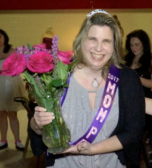 Deana Michalak smiles after being named queen of the Mom Prom at St. Thomas a’Becket Catholic Church in Canton Township, Mich. Mom Prom is an annual event at which women don their old prom, bridesmaid or wedding dresses and gather for an evening of charitable revelry at the suburban Detroit church. (AP Photo/Mike Householder)