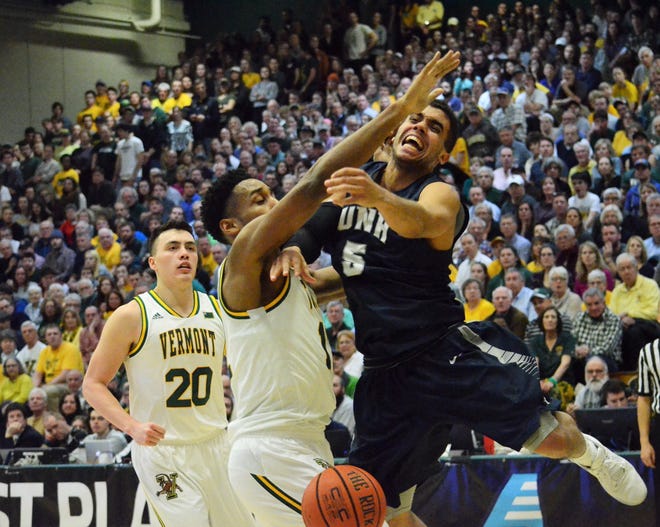 New Hampshire senior guard Daniel Dion (5) has the ball knocked away by Vermont defender Darren Payen during the first half of Monday's America East semifinal game at UVM.