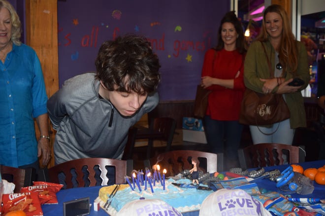 Gaige Mendez blows out the candles on his birthday cake Saturday at the Village of Baytowne Wharf. [PHOTOS BY ABRAHAM GALVAN/ THE LOG]