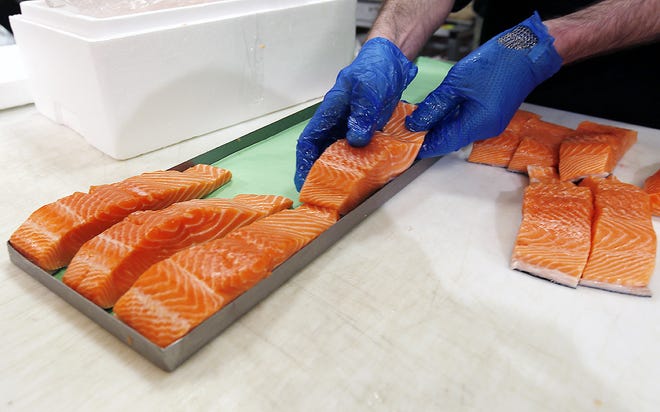 In this April 10, 2015 photo, Canadian certified organic farm-raised King Salmon filets are placed on a tray in a store in Fairfax, Va. Overeating or under-eating 10 foods and nutrients contributes to nearly half of U.S. deaths from heart disease, strokes and diabetes, a study released on March 7 suggests. "Good" foods that were under-eaten include: nuts and seeds, seafood rich in omega-3 fats including salmon and sardines; fruits and vegetables; and whole grains. [ALEX BRANDON/AP]
