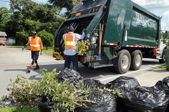 City of Wilmington Solid Waste Department employees pick up trash and yard debris in Wilmington. While burning yard debris is prohibited within city limits, Wilmington does offer free yard debris pickup as part of its trash pickup services. [STARNEWS FILE PHOTO]