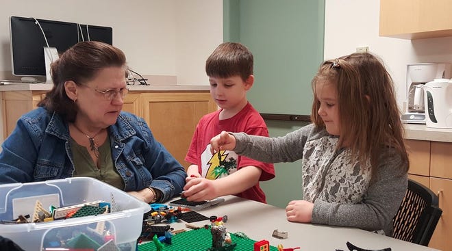 Cheryl Turner watches on as grandson and granddaughter Roland and Sofia Saavedra learn through LEGOs at the Blue Ridge Summit Library.