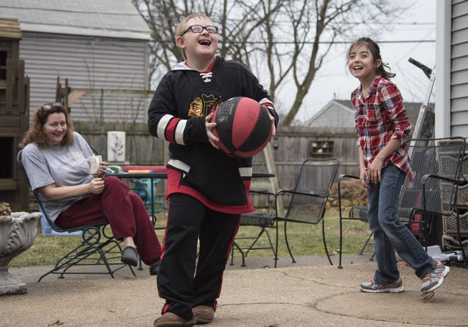 Amadeus Russo (center) plays basketball in the backyard of his house on Tuesday, Feb. 28, 2017, along with his mom Stefanie McKinney and classmate Paige Edgren. [KAYLI PLOTNER/RRSTAR.COM STAFF]