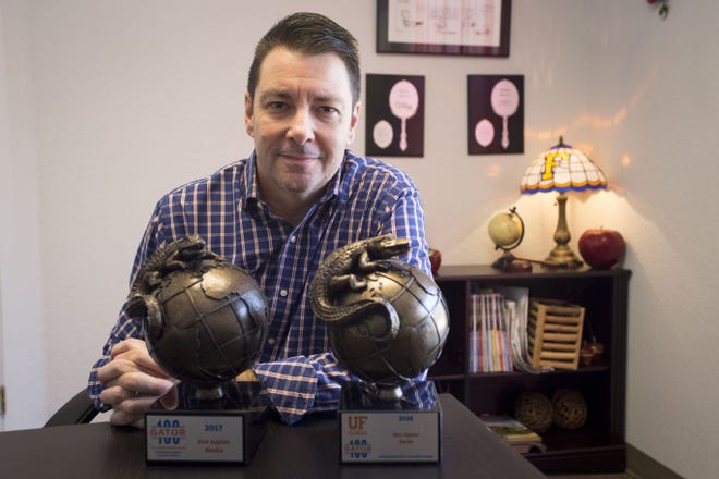 Red Apples Media founder and president Marc Robertz-Schwartz proudly showcases the awards for placing in the University of Florida Gator 100 in 2016 and 2017. [CINDY DIAN / CORESPONDENT]