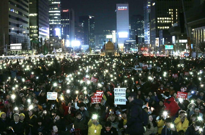 Protesters hold up their smart phone lights during a rally calling for impeached President Park Geun-hye's arrest in Seoul, South Korea on Friday. Constitutional Court removed impeached President Park Geun-hye from office in a unanimous ruling Friday over a corruption scandal that has plunged the country into political turmoil and worsened an already-serious national divide. [AHN YOUNG-JOON / ASSOCIATED PRESS]