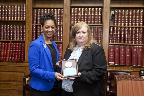 Sebastian County Clerk Sharon Brooks, left, is presented with a NASS Medallion Award by Leslie Bellamy, right, director of elections for the Arkansas secretary of state. [SUBMITTED PHOTO]