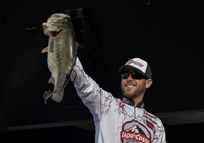 Angler Aaron Britt holds up a 9 pound, 8 ounce bass at the FLW Tour presented by Ranger in Leesburg on Saturday. [PAUL RYAN / CORRESPONDENT]