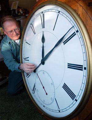 This Friday, March 31, 2006 file photo shows Pat Boyden, owner of the Green Mountain Clock Shop in Williston, Vt., as he sets the time forward on one of the hundreds of clocks in his shop in preparation for daylight saving time. (AP Photo/Rob Swanson)