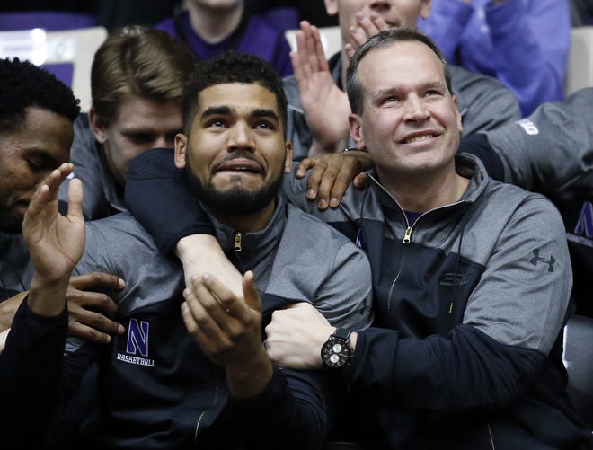 Northwestern coach Chris Collins, right, and guard/forward Sanjay Lumpkin react while watching television coverage of the NCAA men's basketball tournament selection show, Sunday, March 12, 2017 at Welsh-Ryan Arena in Evanston, Ill. Northwestern, in its first tournament appearance, will play Vanderbilt. THE ASSOCIATED PRESS