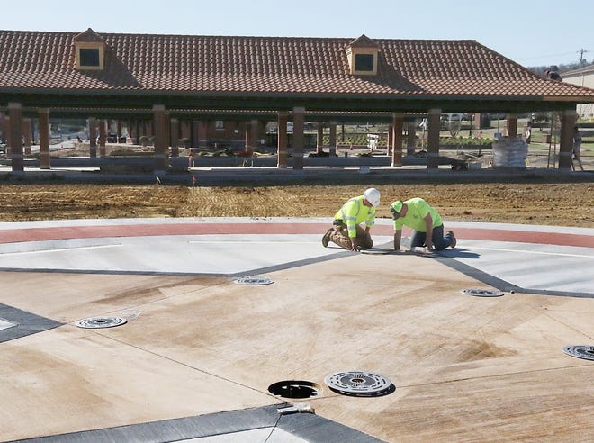 Crawford Construction Superintendent Sterling Kious, left, and Splash Tech's Lorne Greene, work on one of the water jets on the interactive splash pad, Friday, March 10, 2017, at the Van Buren Veteran's Memorial Freedom Park next to the train depot. The new Freedom Park covers two acres, includes two pavilions, additional parking and the Mother's Gold Star water feature and is scheduled for opening in April. [JAMIE MITCHELL/TIMES RECORD]