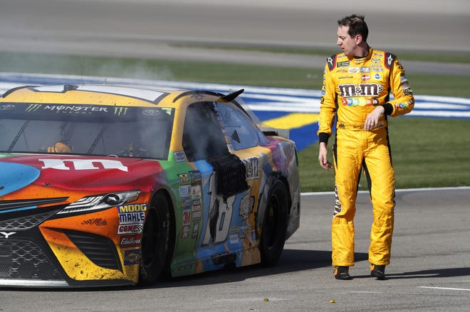 Kyle Busch walks away from his smoking car in pit lane before he heads into the pit area to look for Joey Logano, where a heated Busch and Logano had to be separated on Sunday. [Steve Marcus/Las Vegas Sun via AP]